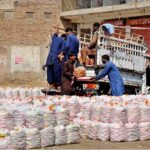 Labourers are busy unloading tomato bags from the delivery van at the Vegetable Market