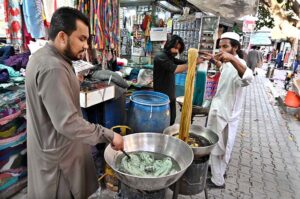 Workers dying clothes as per customers demand ahead of Eid-ul-Fitr at Aabpara Market