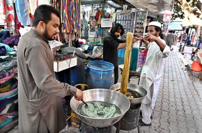 Workers dying clothes as per customers demand ahead of Eid-ul-Fitr at Aabpara Market