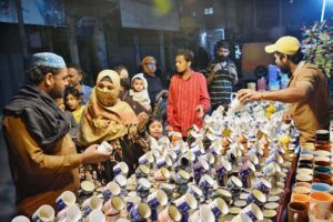 Families selecting and purchasing tea cups from vendor at Fort Road.