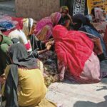 Women select and buy colorful bangles from the roadside sitting women vendors in preparation for the upcoming Eid al Fitr