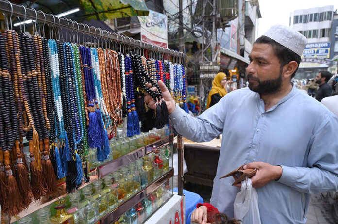 Customer selecting beads for prayer from roadside vendor at Sadar Bazar
