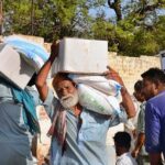 Deserving people on the way back while carrying rashan bags distributed by volunteers at Dialdas Club