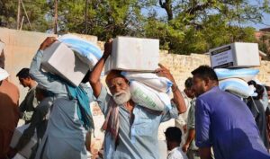 Deserving people on the way back while carrying rashan bags distributed by volunteers at Dialdas Club