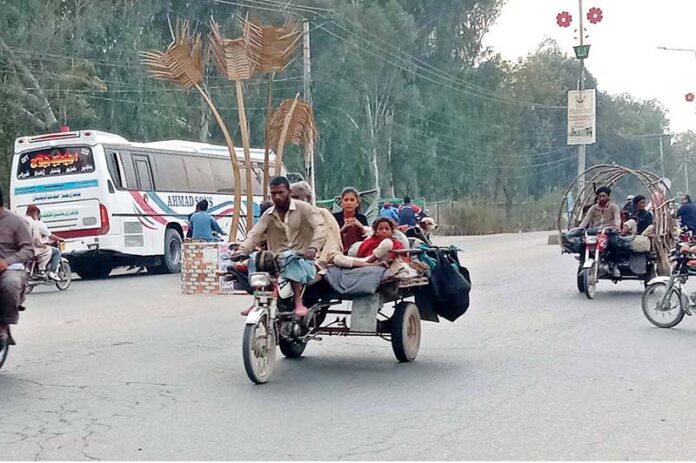 A nomad family navigates the roads of Bahawalpur on a motorcycle rickshaw
