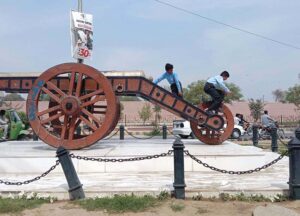 School students playing with a historical gun from the princely state of Bahawalpur, a relic of the past standing tall at Fareed Gate Chowk