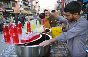A street vendor prepares a variety of colorful syrups to quench thirst and attract customers during the holy month of fasting in the city