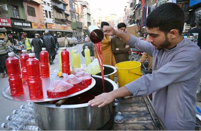 A street vendor prepares a variety of colorful syrups to quench thirst and attract customers during the holy month of fasting in the city