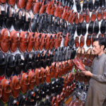 A man busy in selecting and purchasing shoes in connection with upcoming Eid-ul-Fitr at Resham Gali