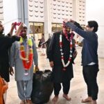The faithful are welcomed by their relatives after completing i'tikaf and emerging from Faisal Masjid upon the sighting of the Shawwal moon