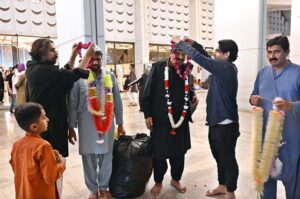The faithful are welcomed by their relatives after completing i'tikaf and emerging from Faisal Masjid upon the sighting of the Shawwal moon