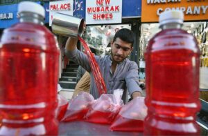 A street vendor prepares a variety of colorful syrups to quench thirst and attract customers during the holy month of fasting in the city