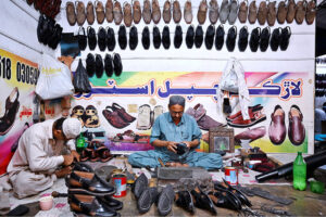 A man busy in selecting and purchasing shoes in connection with upcoming Eid-ul-Fitr at Resham Gali