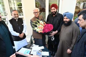 Defense Minister Khawaja Muhammad Asif receives a bouquet from a Sikh community delegation at his residence