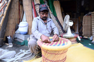 A worker prepares hand-made stools at his workplace.
