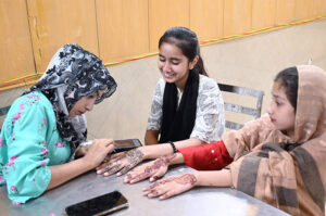 Girls getting henna on their hands in preparation of Eid ul Fitr celebrations