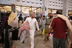 The faithful are welcomed by their relatives after completing i'tikaf and emerging from Faisal Masjid upon the sighting of the Shawwal moon