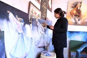 A woman puts the final touches on her painting at H-9 Weekly Bazaar in connection with Women's Day.