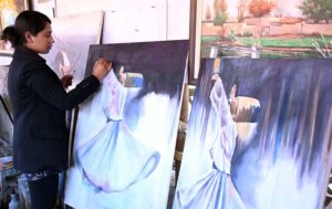 A woman puts the final touches on her painting at H-9 Weekly Bazaar in connection with Women's Day.