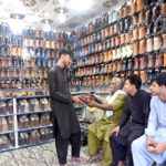 Customers at Chamra Market near Allama Iqbal Road purchasing leather Peshawari Chapal in preparation for the upcoming Eid-ul-Fitr