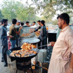 A man is frying samosas to sell at his roadside stall