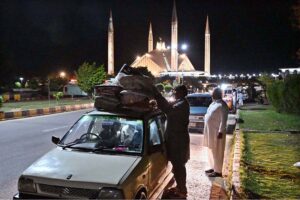 The faithful are welcomed by their relatives after completing i'tikaf and emerging from Faisal Masjid upon the sighting of the Shawwal moon