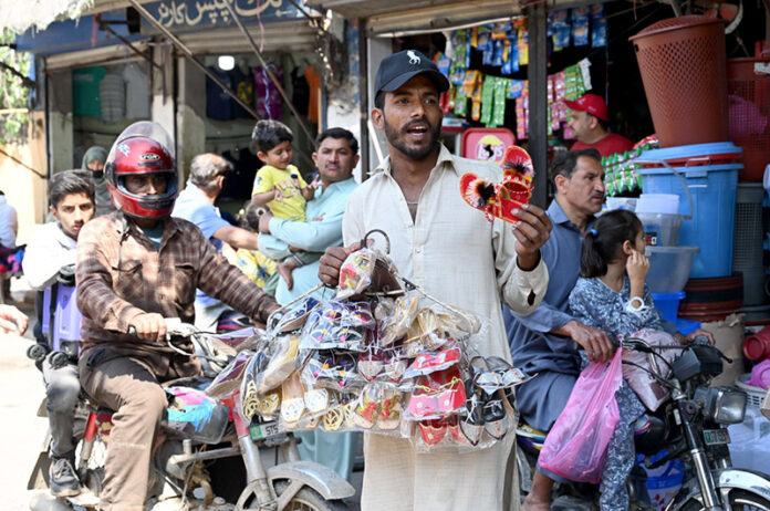 A vendor is selling home decoration items at the road side to earn for livelihood A vendor is selling home decoration items at the road side to earn for livelihood