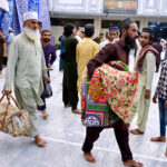 Worshipers entering in Faizan-E-Madina Mosque carrying their belongings to sit for Itikaf, an Islamic meritorious voluntary practice of secluding oneself in a mosque for a period of time, dedicating it to worship and spiritual reflection, typically during Ramadan