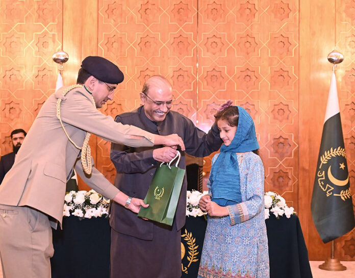 President Asif Ali Zardari distributing computer tablets among orphaned children during an Iftar Dinner hosted by him, at Aiwan-e-Sadr