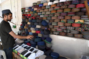 A man decorates prayer caps to attract the customers in preparation for the 27th Ramadan the last Friday prayers in the City