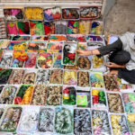 A woman vendor shows colourful bangles to the customers at Resham Gali during shopping for upcoming Eid Ul Fitr