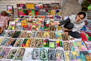 A woman vendor shows colourful bangles to the customers at Resham Gali during shopping for upcoming Eid Ul Fitr