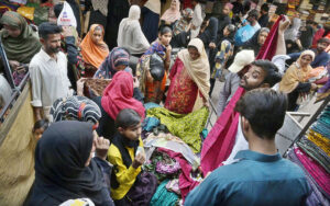 Women selected and purchasing ladies cloth from a vendor at Resham bazaar.