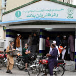 A large number of people busy filing drinking water at a water filtration plant at I-10 sector