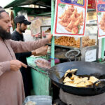 A street food vendor prepares samosas, a traditional food item for iftar, during the holy month of Ramadan