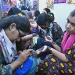 Artisans applies henna (mehndi) to girls’ hands as they prepare for Eidul Fitr celebrations at Meena Bazaar