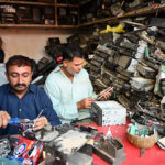 Mechanics repairing car tapes at their workplace