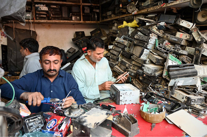 Mechanics repairing car tapes at their workplace