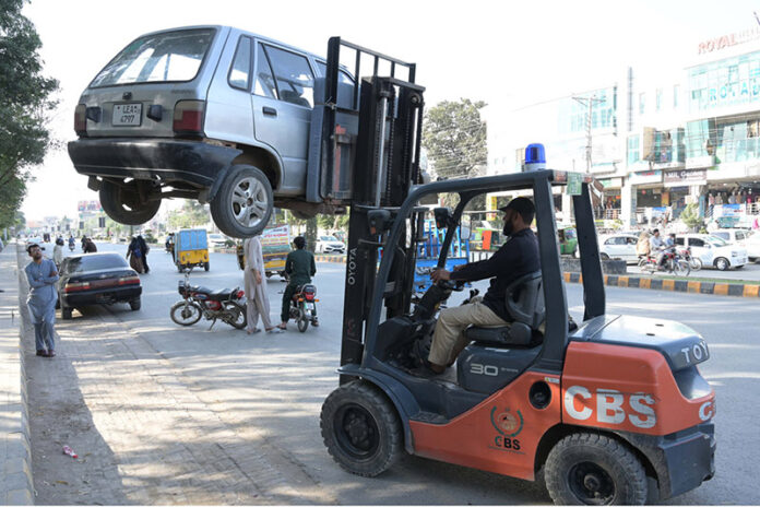 A traffic lifter removing wrong parked car at college Road