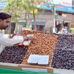 A Date vendor on Chaubarji Road, displaying and decorating different types of dates to attract the customers