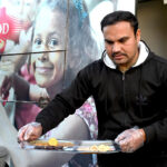 A worker serves free food to people in fasting during Iftar arranged by Umeed Food Trust at G-8 in the federal capital