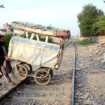 A man crossing a cart through the railway track of the Kot Lakhpat railway line towards his destination