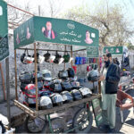 Vendors sells motorcycle helmets on a handcart provided by the government of Punjab
