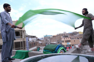 Workers drying clothes after dye on a rooftop at their work place in Fawara Chowk.