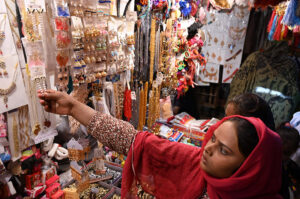 A girl selecting artificial jewelries during shopping in preparation of upcoming Eid Ul Fitr at Resham Gali