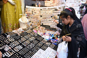A girl selecting artificial jewelries during shopping in preparation of upcoming Eid Ul Fitr at Resham Gali