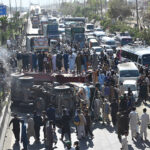 A large number of people gathered around a flip over truck collided with passenger vans due to over speed at IJP Road resulted causalities of four people on the spot