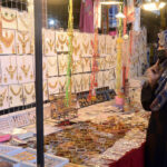 A woman looking for jewelry during Eid-ul-Fitr shopping at Anarkali market