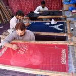 Skilled workers preparing embroidery clothes due to the increased demand for upcoming Eid-ul-fitr near Umayya colony