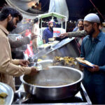 A vendor displaying and selling traditional food stuff to customers for Sehri at Gwalmandi Food Street during the Fasting Month of Ramzanul Mubarak